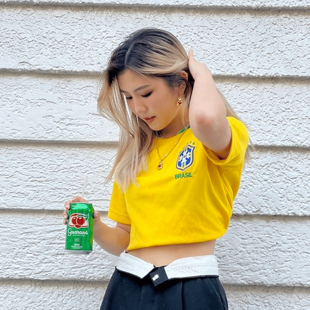 Mulher usando camiseta da seleção brasileira amarela
